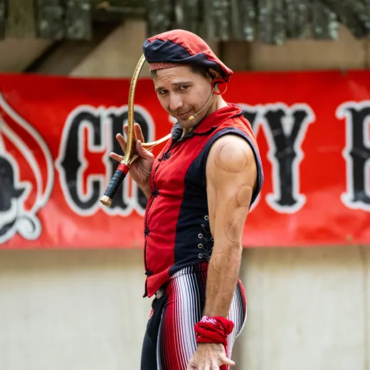 Crazy Boy Coy in red and black stripes, juggling club in hand