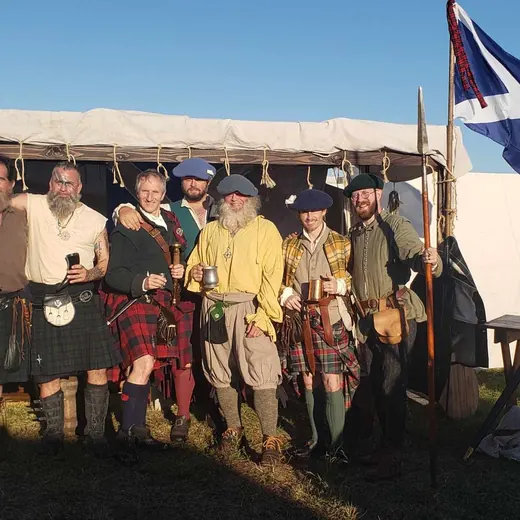 The Queen's Highland Guard in kilts at their encampment under a Scottish saltire